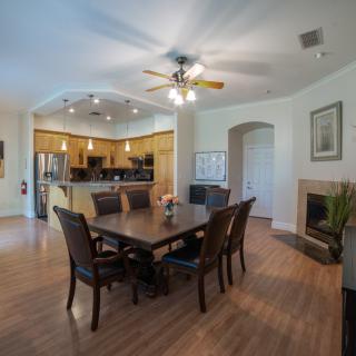 A spacious dining area with an open view into the kitchen, featuring modern furnishings and a warm atmosphere.