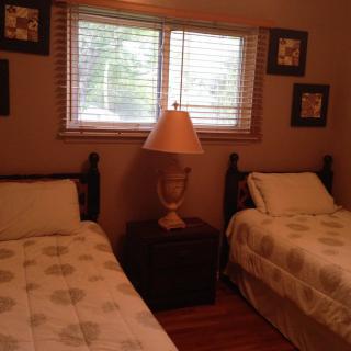 A cozy bedroom with two twin beds and a lamp between them.