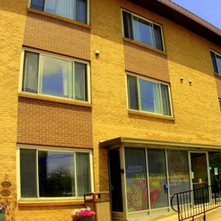 A three-story brick apartment building with large windows.