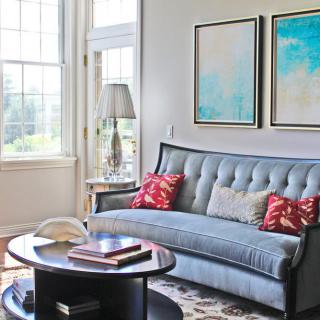 A cozy living room with a stylish sofa, colorful pillows, and abstract artwork.