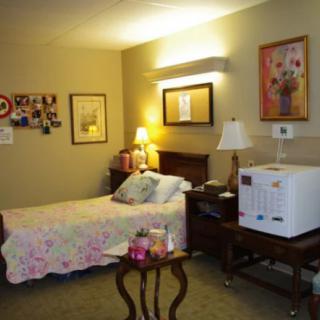 A cozy bedroom with a single bed, bedside tables, and warm lighting.