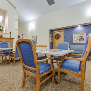 A cozy dining area with blue upholstered chairs and a wooden table.