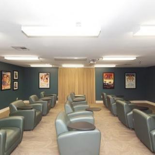 A spacious waiting room with comfortable seating and wall posters.