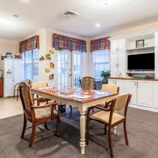 A cozy dining area with a wooden table and chairs, adjacent to a kitchen space.