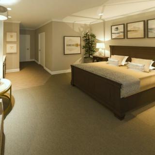 A spacious bedroom with elegant furnishings and neutral-toned decor.
