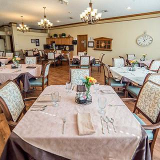A well-arranged restaurant dining area with neatly set tables and elegant chandeliers.