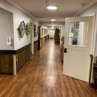 A well-lit hallway with wooden flooring and decorative elements on the walls.