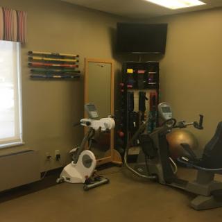 A well-equipped indoor gym area featuring exercise machines and fitness accessories.