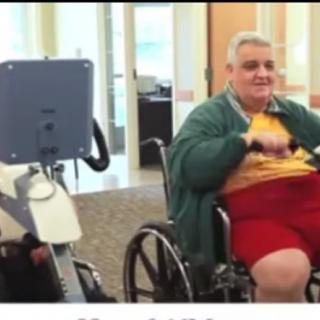 A person in a wheelchair using exercise equipment indoors.