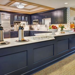 A modern kitchen with dark cabinetry and a stylish coffee station.