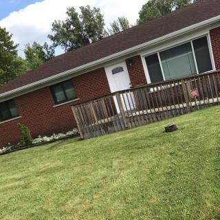 A single-story brick house with a well-maintained front lawn.