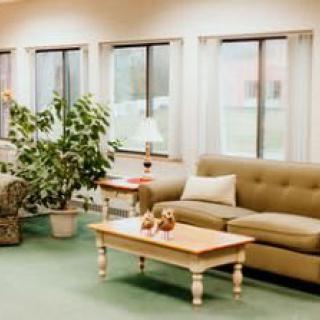 A cozy living room with a sofa, coffee table, and large windows letting in natural light.