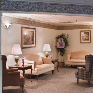 A cozy living room with sofas, lamps, and decorative artwork.