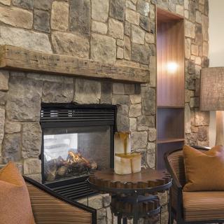 A cozy living room with a stone fireplace and comfortable seating.