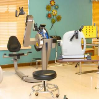 A rehabilitation room with various exercise machines for therapy.