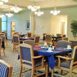 A well-lit dining area with neatly arranged tables and chairs.