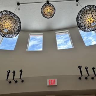 A modern interior with unique ceiling lights and windows letting in natural light.
