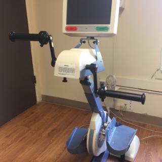 A rehabilitation exercise bike designed for physical therapy, featuring hand grips and a digital display.