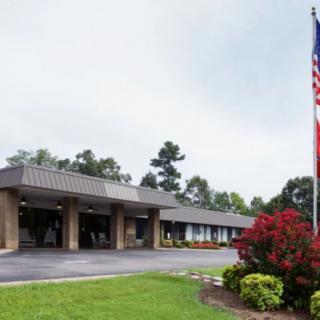 An exterior view of a building with a flagpole and landscaped surroundings.