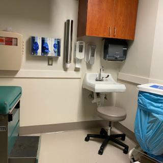 A view of a medical examination room featuring essential medical equipment and a clean, organized environment.