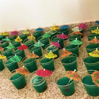 A vibrant display of green cups topped with colorful umbrellas, perfect for a festive gathering.