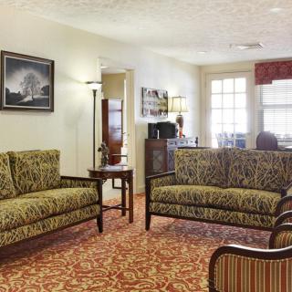 A cozy living room with patterned sofas and warm lighting.