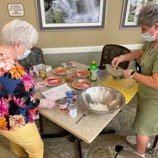 Two people preparing ingredients for baking at a table.