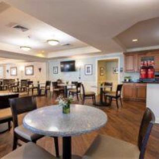A modern dining area with several tables and chairs, featuring a clean and bright interior design.