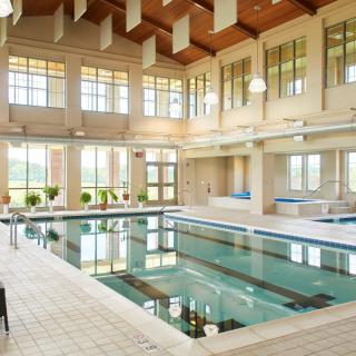 A spacious and well-lit indoor swimming pool with elegant architecture.