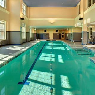 An inviting indoor swimming pool with natural light streaming in.