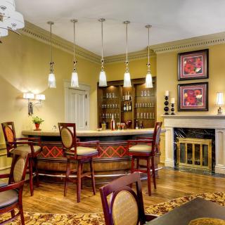 A stylish home bar setup with elegant furnishings and ambient lighting.