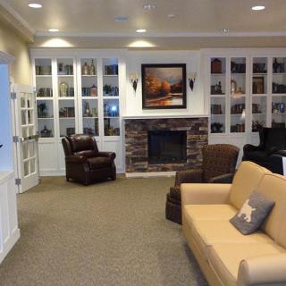 Cozy living room with a fireplace, surrounded by bookshelves and comfortable seating.