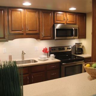 Modern kitchen with wooden cabinets and stainless steel appliances.