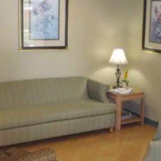 A cozy living room with a sofa, lamp, and artwork on the walls.