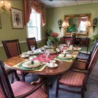 A beautifully set dining room with a wooden table and elegant decor.