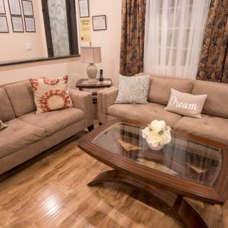 A cozy living room with two sofas, a wooden coffee table, and decorative cushions.