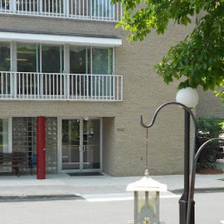 A modern residential building featuring balconies and a street lamp.