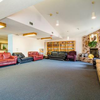 A spacious living room with multiple sofas and decorative elements.