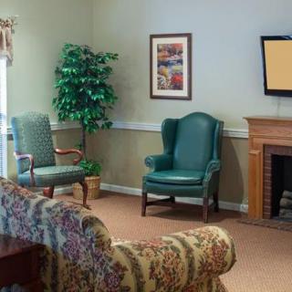 A cozy living room with seating, a TV, and decorative elements.