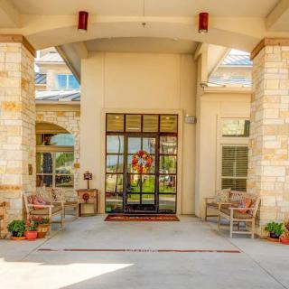 A welcoming entrance with large glass doors, flanked by chairs and decorative elements.