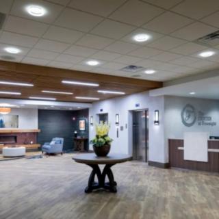 Modern office lobby with a reception desk and seating area.