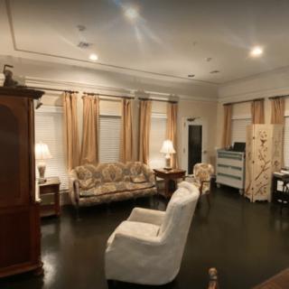 A spacious living room with elegant furniture and warm lighting.