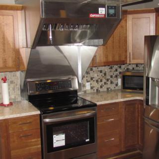 Modern kitchen with stainless steel appliances and wooden cabinets.