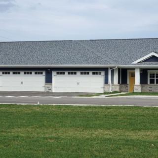 A modern residential house with a large garage and a well-maintained lawn.