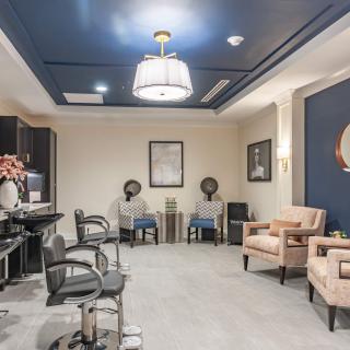 A modern salon interior with styling chairs, hair dryers, and a comfortable waiting area.