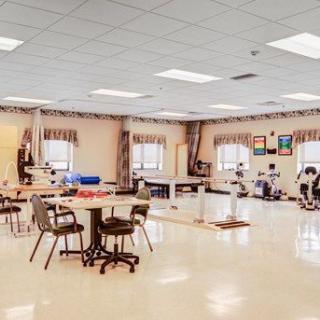 A spacious rehabilitation facility equipped with exercise equipment and seating areas.