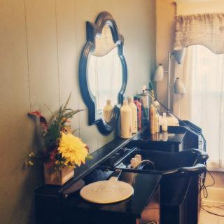 A vintage-style bathroom with a decorative mirror, double sinks, and floral arrangements.