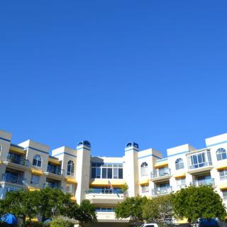 A modern apartment building with a clear blue sky in the background.
