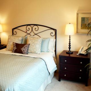 A cozy bedroom with elegant decor, featuring a comfortable bed and stylish nightstands with lamps.
