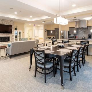 A modern open-plan living space featuring a dining area, kitchen, and seating in a contemporary interior.